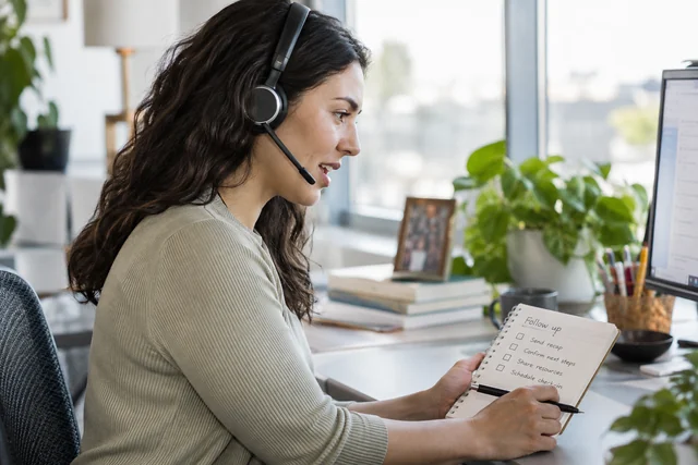 An adult customer-success professional wearing a headset.